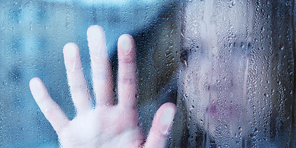 woman looking out rainy window